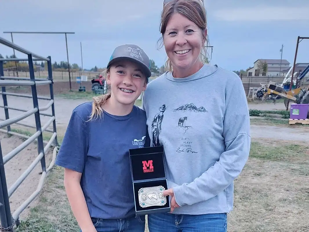 Awarding a belt buckle to a Dedicated Rider participant